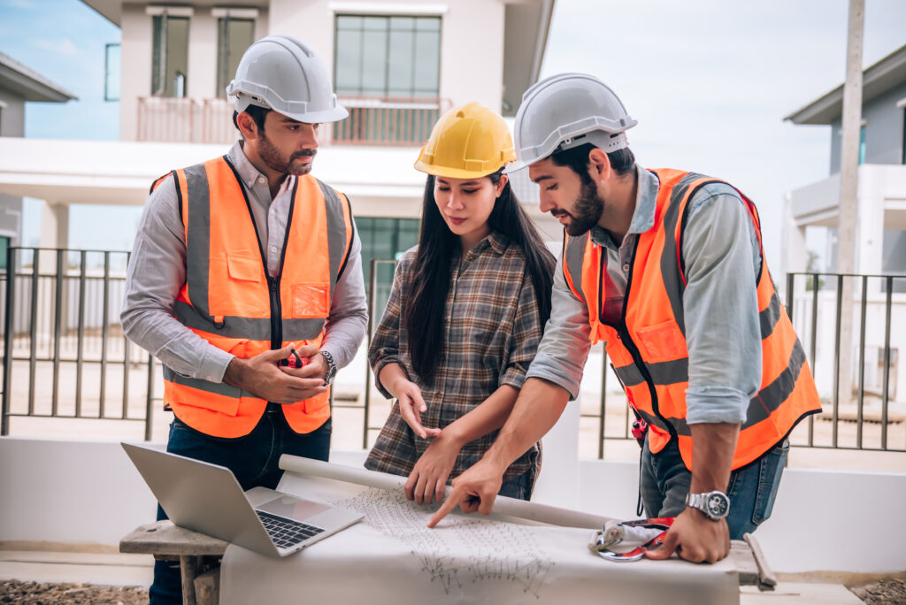 civil engineer construction worker architects wearing hardhats safety vests are working together construction site building home cooperation teamwork concept civil engineer construction worker architects wearing hardhats safety vests are working together construction site building home cooperation teamwork concept